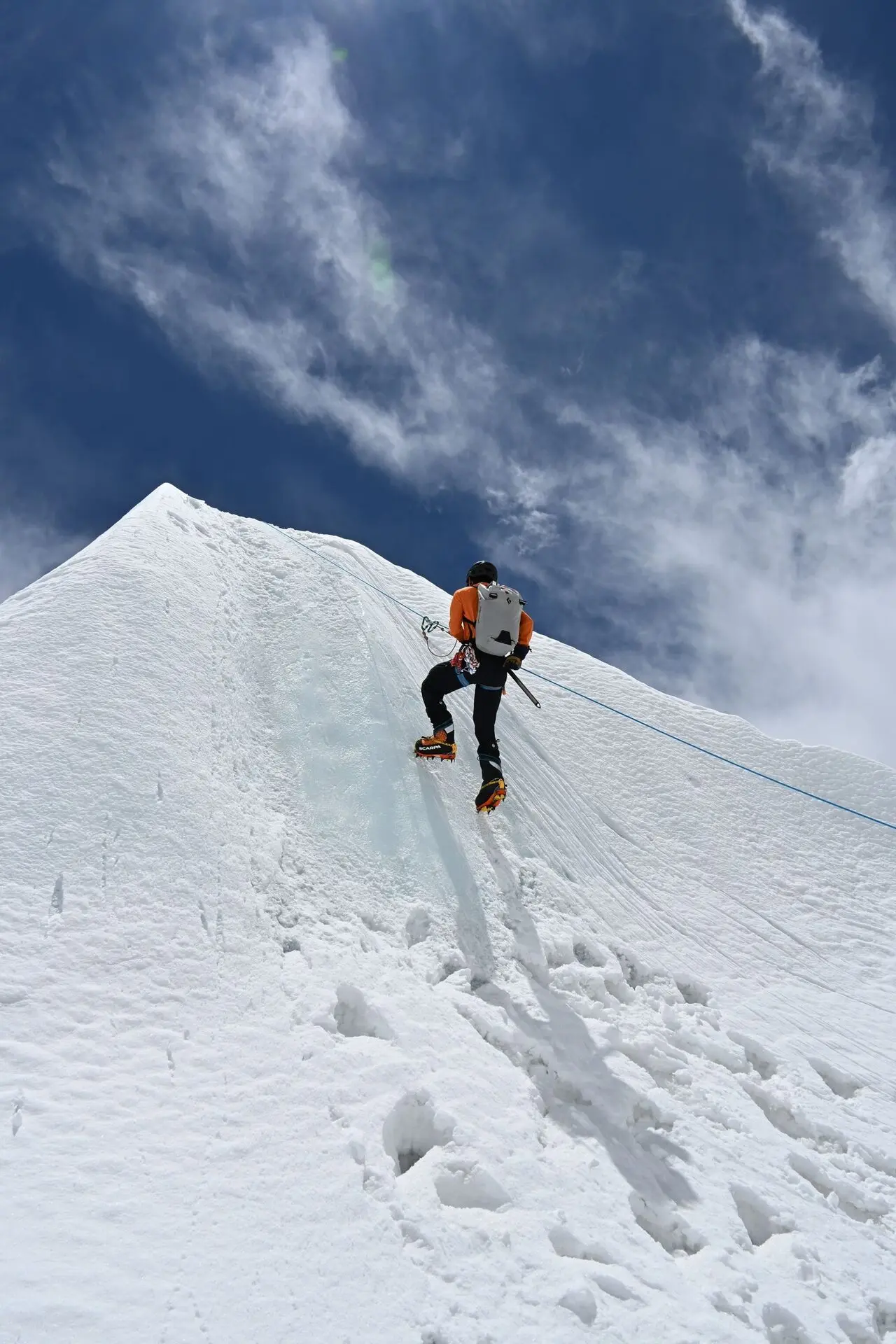 Alpinista ascendiendo por una arista nevada del Himalaya